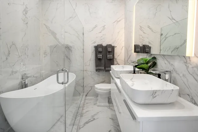 a bathroom with a granite countertop sink a toilet and bathtub
