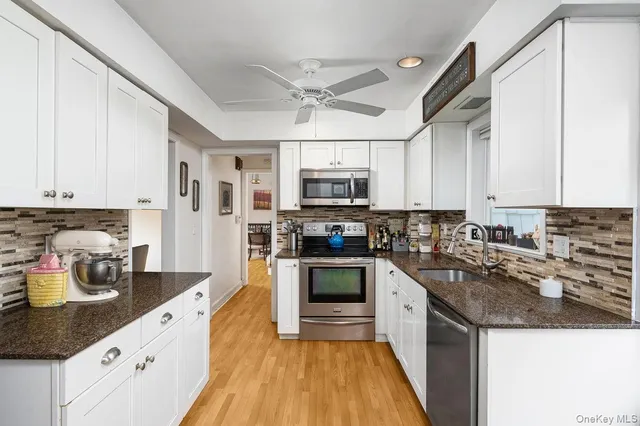 a kitchen with a sink a counter top space cabinets and stainless steel appliances