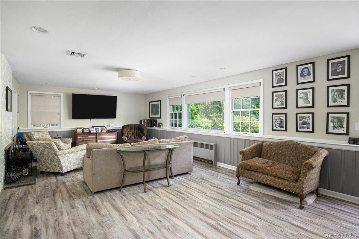 4 Wagon Wheel Road Mamaroneck, NY 10543 - Photo 19 of 31 Living room with wainscoting, radiator, wood finished floors, and wooden walls