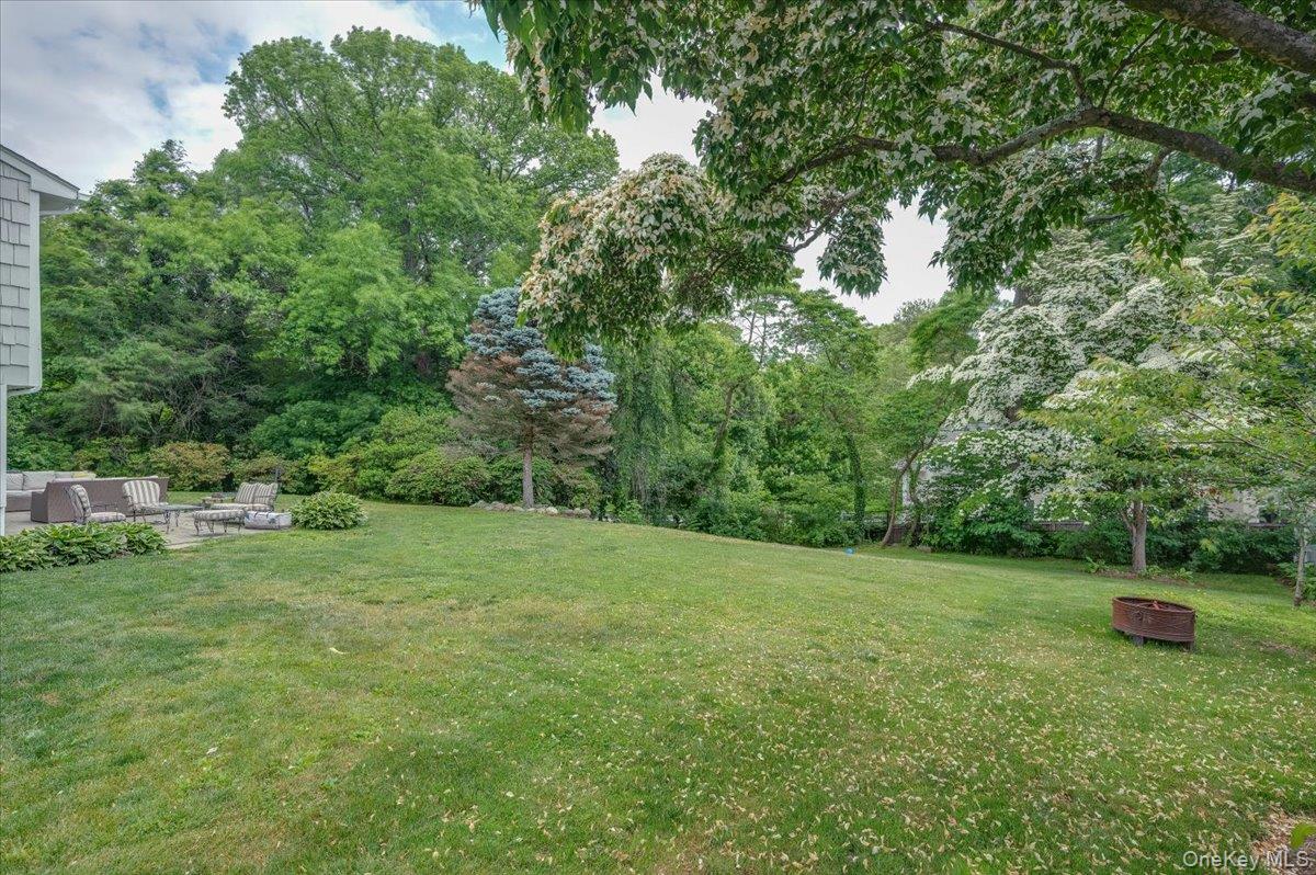 4 Wagon Wheel Road Mamaroneck, NY 10543 - Photo 4 of 31 View of green lawn featuring an outdoor living space with a fire pit and a patio area