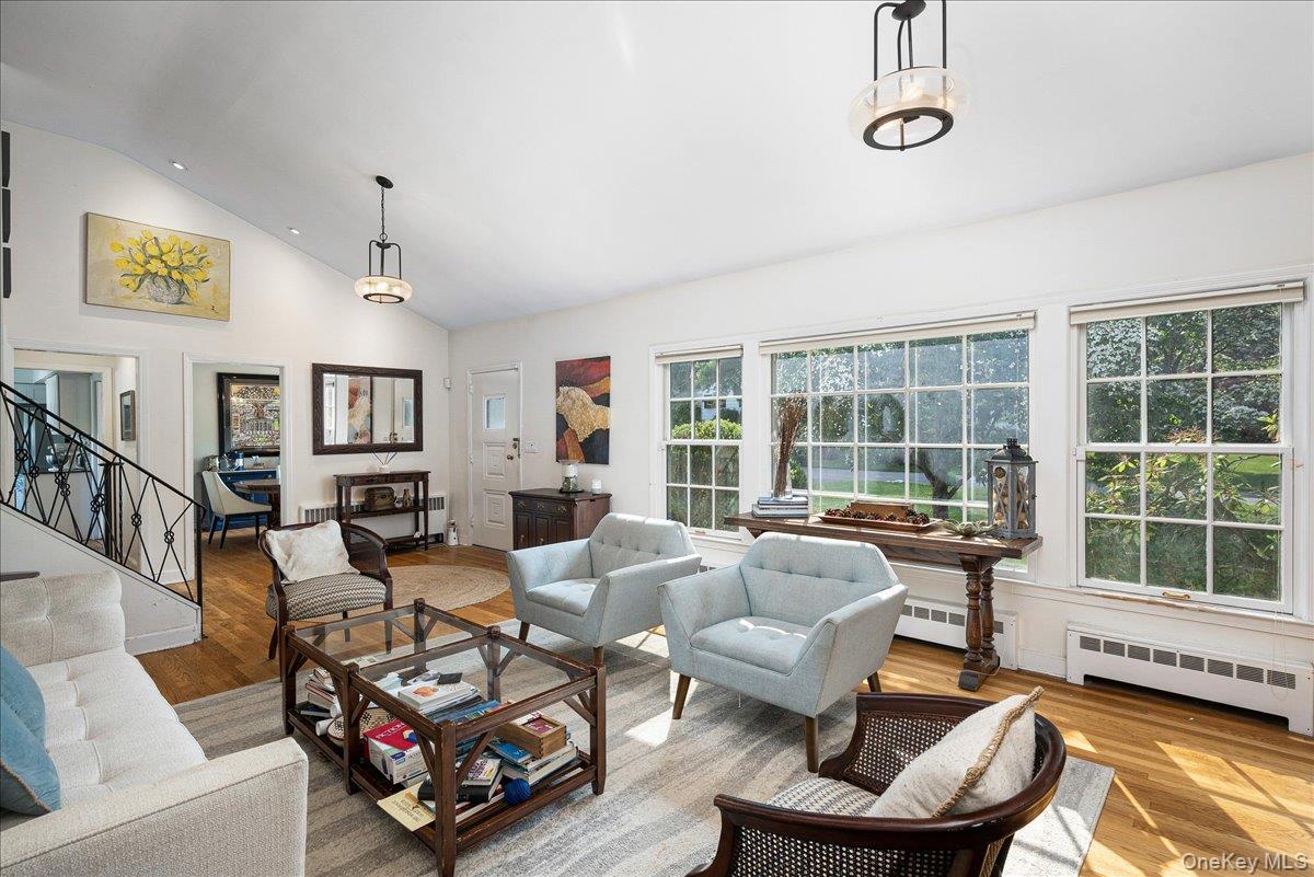 4 Wagon Wheel Road Mamaroneck, NY 10543 - Photo 8 of 31 Living room with wood finished floors, stairway, radiator, high vaulted ceiling, and a baseboard radiator