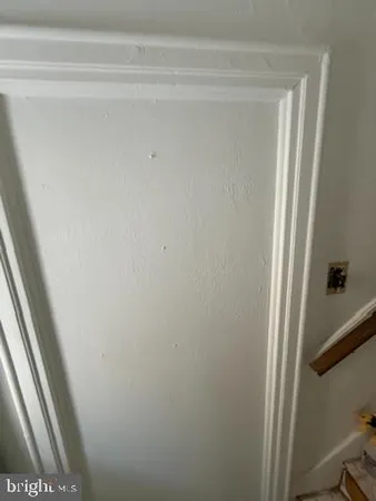 an empty room with chandelier fan and windows