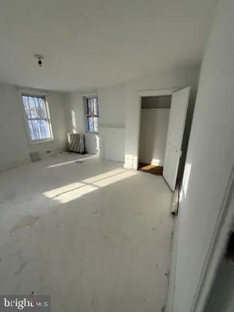 a living room with a black white checkered floor with a gaming machine and wooden floor