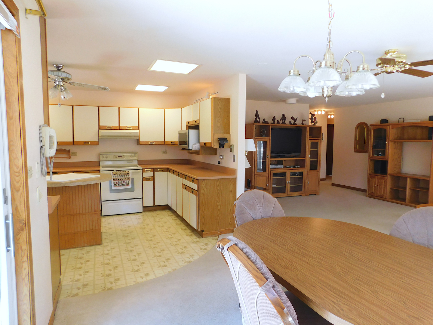 4496 West Sandwich Road Sandwich, IL 60548 - Photo 12 of 37 a kitchen with stainless steel appliances granite countertop a sink dishwasher and a flat screen tv