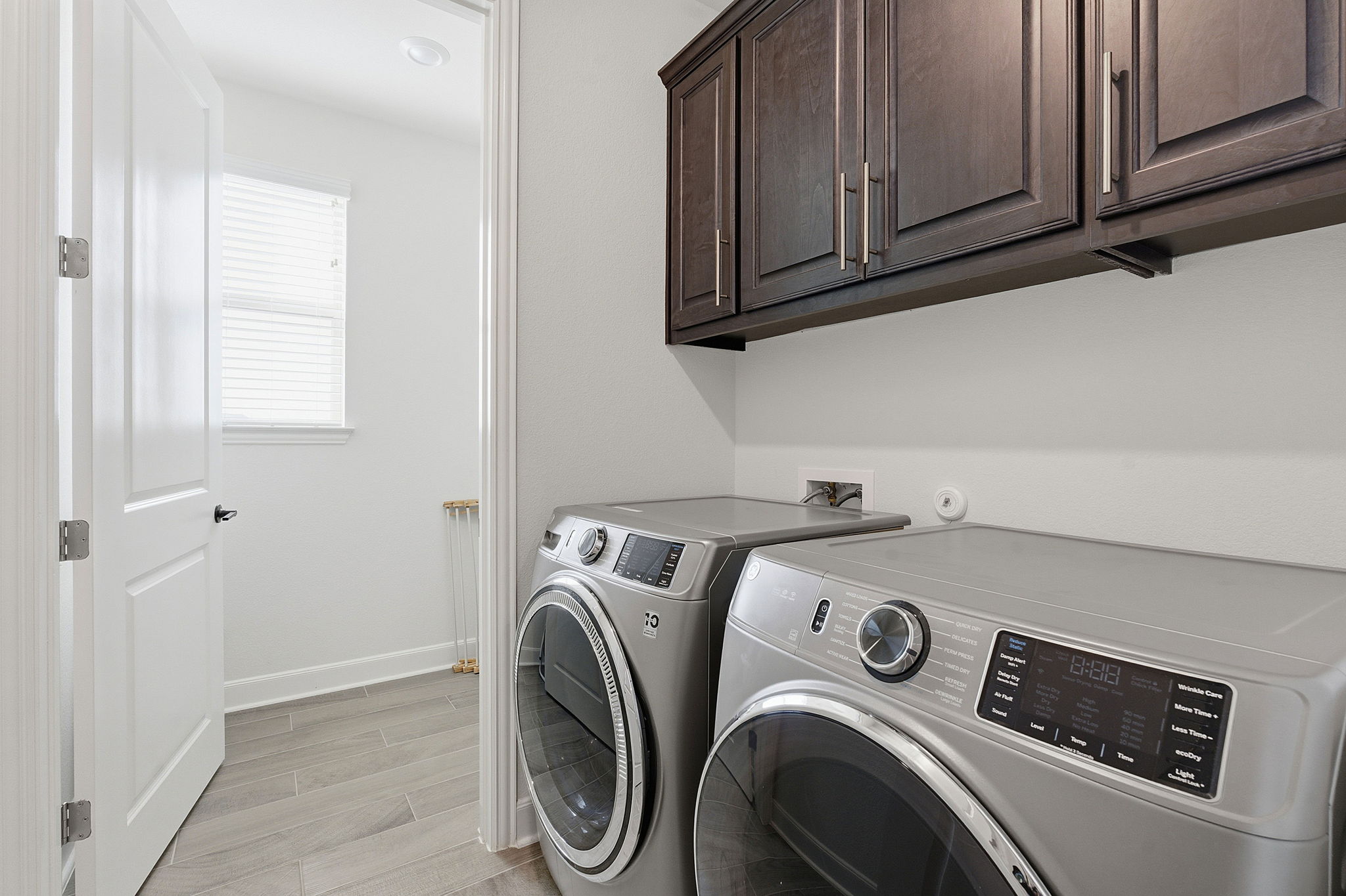 18917 Grape Seed Cove Austin, TX 78738 - Photo 15 of 33 Laundry room with cabinet space, wood finish floors, and washer and dryer