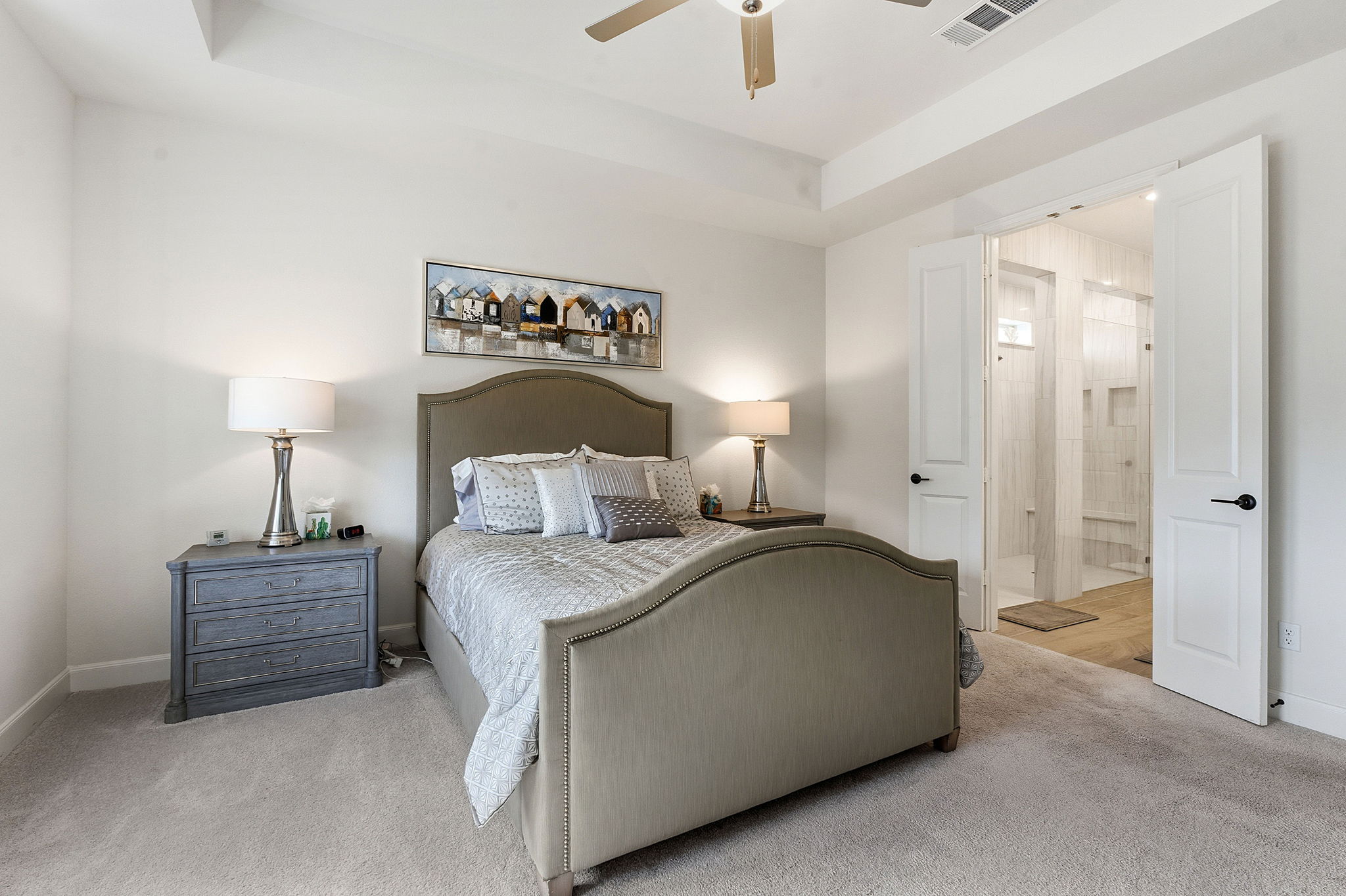 18917 Grape Seed Cove Austin, TX 78738 - Photo 23 of 33 Bedroom featuring a raised ceiling, carpet, connected bathroom, and ceiling fan