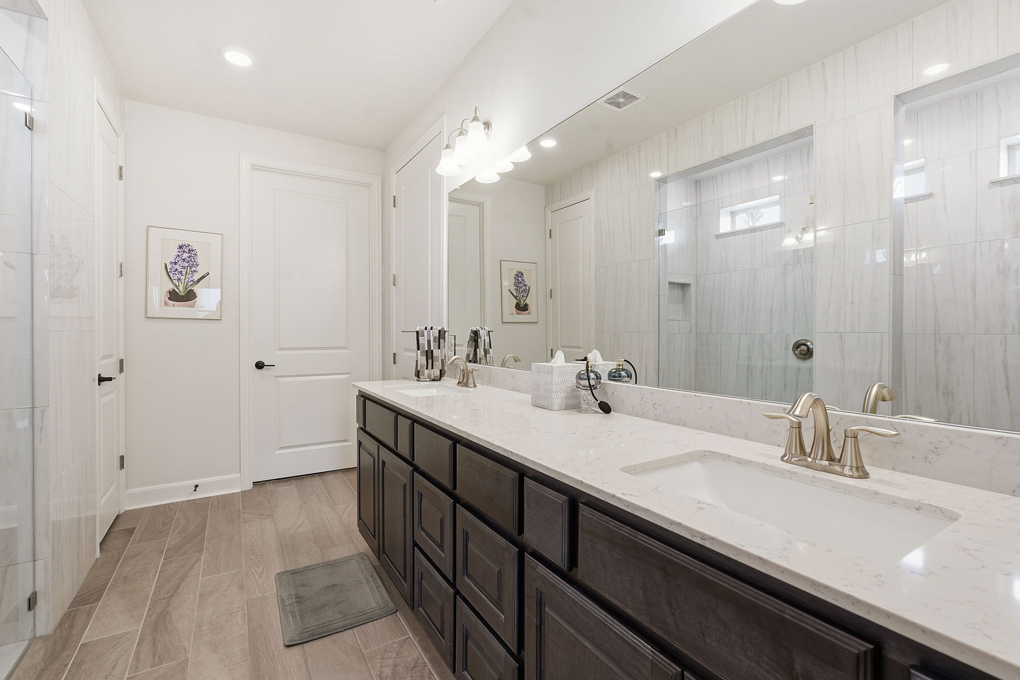 18917 Grape Seed Cove Austin, TX 78738 - Photo 24 of 33 Bathroom featuring a walk in shower, double vanity, and wood tiled floors