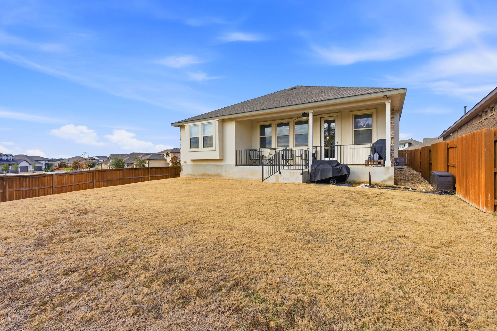 18917 Grape Seed Cove Austin, TX 78738 - Photo 5 of 33 Back of house featuring a patio, a fenced backyard, a residential view, and roof with shingles