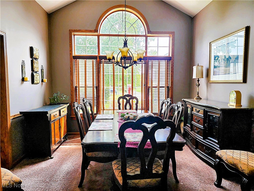 8329 Seasons Road Streetsboro, OH 44241 - Photo 22 of 35 Dining area with carpet flooring, lofted ceiling, and a chandelier
