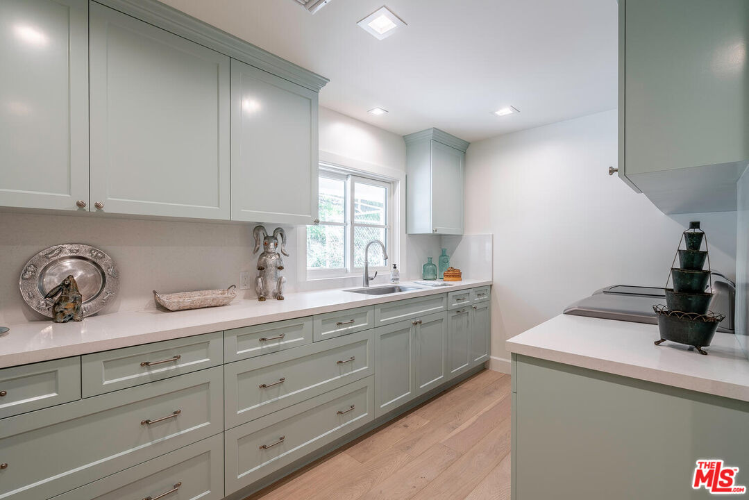 10821 Savona Road Los Angeles, CA 90077 - Photo 13 of 26 a kitchen with granite countertop white cabinets and sink