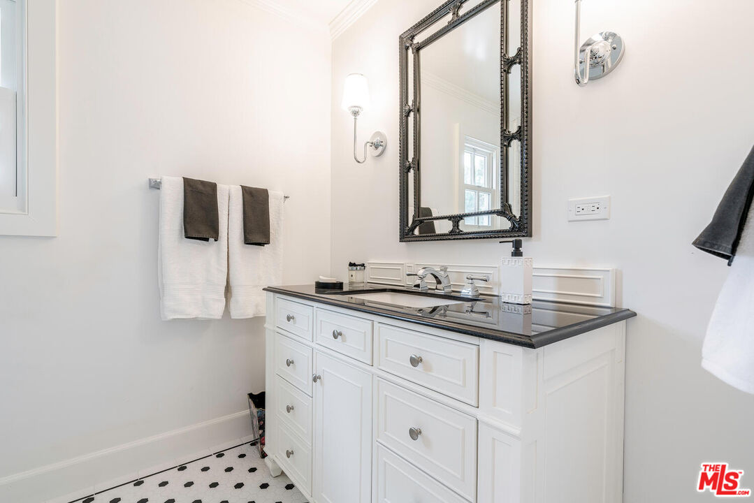 10821 Savona Road Los Angeles, CA 90077 - Photo 21 of 26 a bathroom with a sink and a mirror