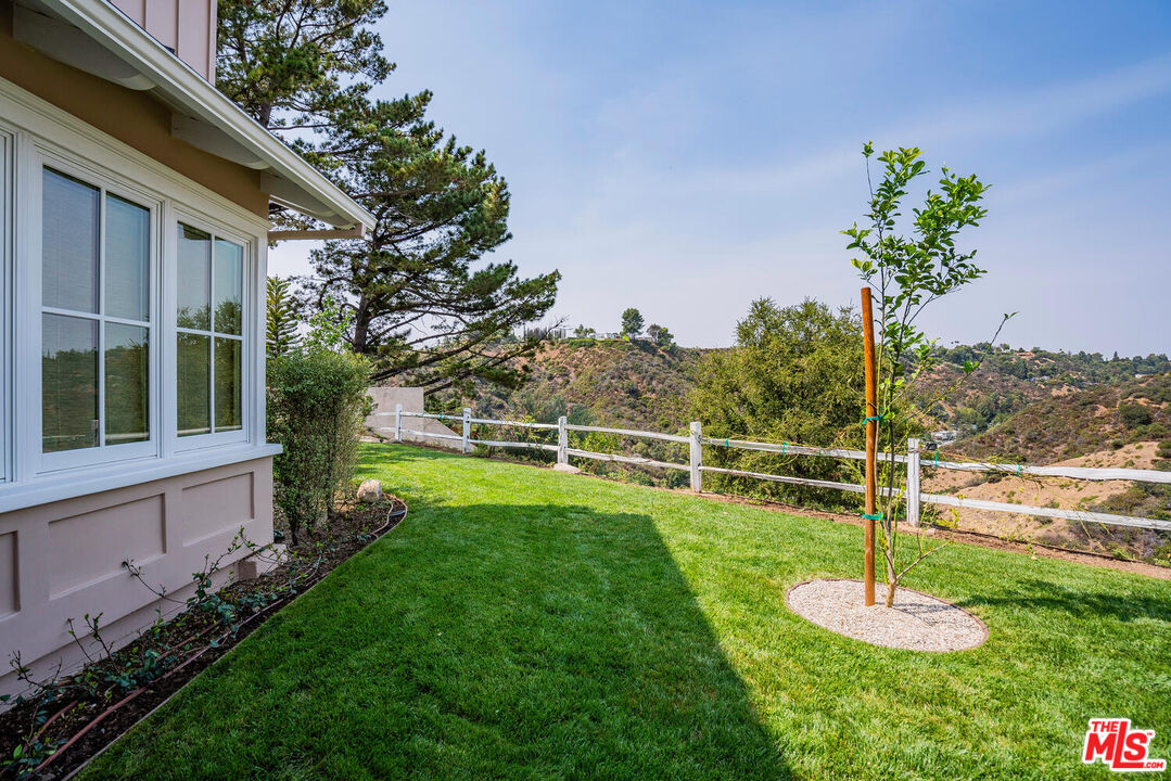 10821 Savona Road Los Angeles, CA 90077 - Photo 25 of 26 a garden with a bench in front of the house