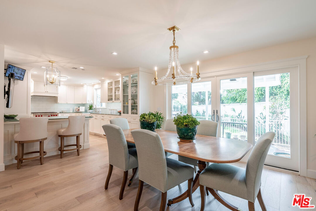 10821 Savona Road Los Angeles, CA 90077 - Photo 7 of 26 a view of a dining room and livingroom with furniture wooden floor a chandelier