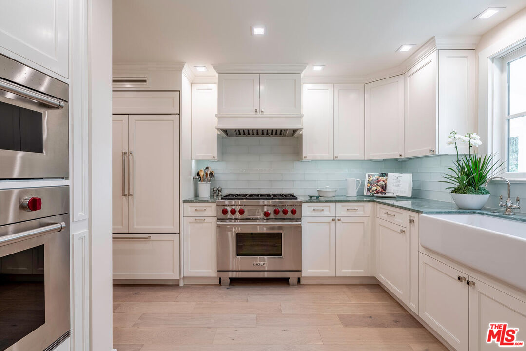 10821 Savona Road Los Angeles, CA 90077 - Photo 9 of 26 a kitchen with cabinets stainless steel appliances and sink