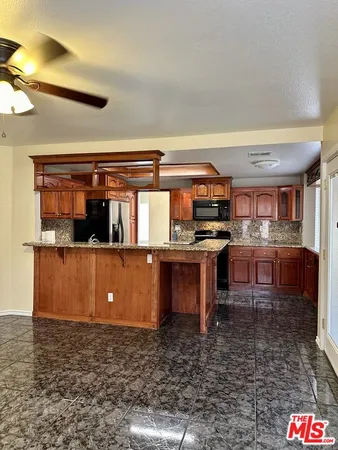 a view of kitchen with stainless steel appliances kitchen island granite countertop a stove and a sink