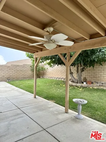 a view of a backyard with table and chairs under an umbrella