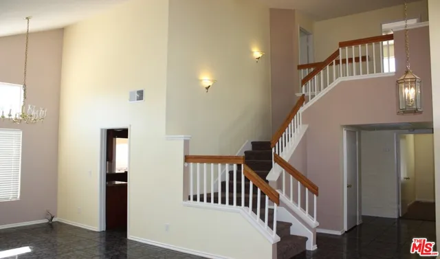 a view of staircase with lots of frames on wall and a window