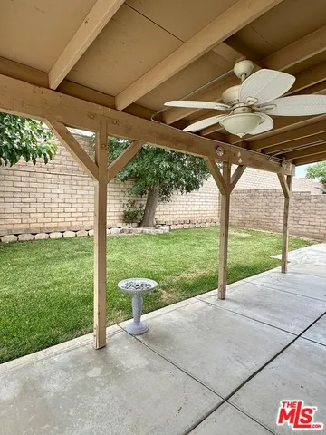 a view of a backyard with table and chairs under an umbrella