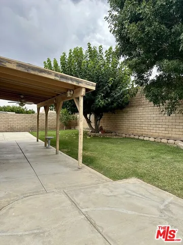 a backyard of a house with table and chairs a barbeque with wooden fence