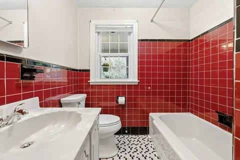 a bathroom with a sink a toilet and a mirror