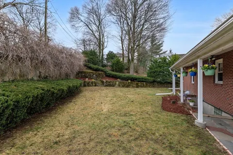 a backyard of a house with fountain table and chairs