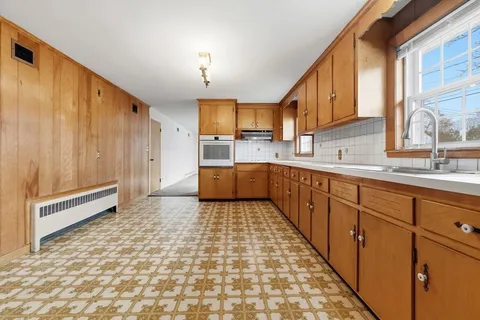 a large kitchen with a sink and cabinets