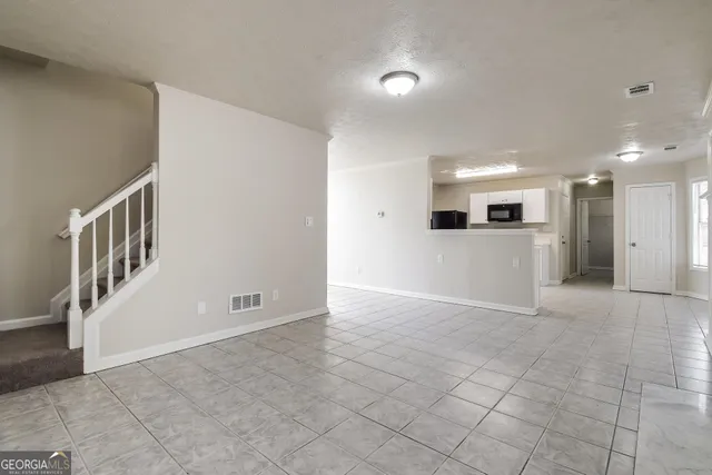 a view of an empty room with a kitchen
