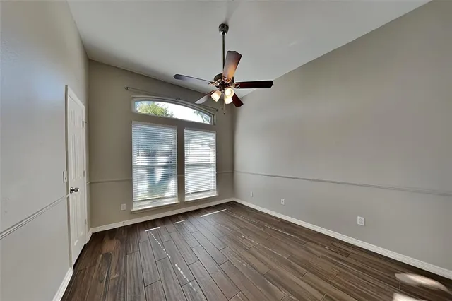 a view of wooden floor and a chandelier fan in an empty room