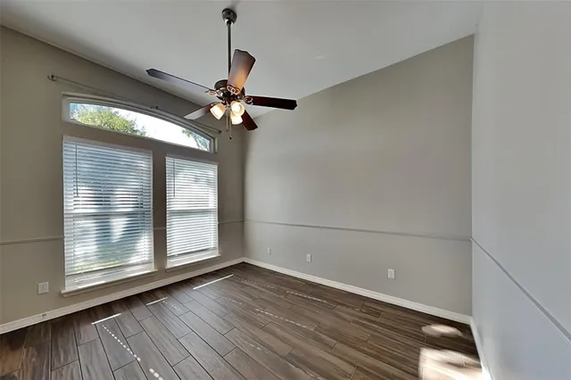 a view of wooden floor and a chandelier fan in an empty room