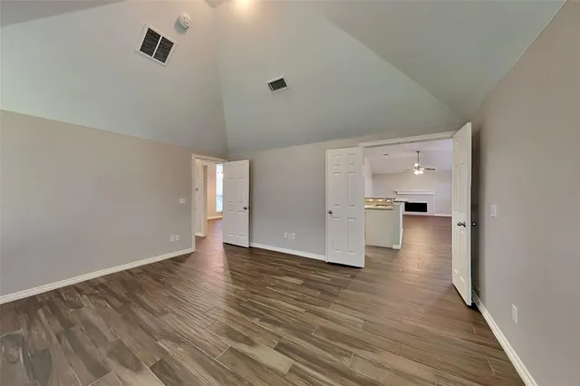 a view of empty room with wooden floor