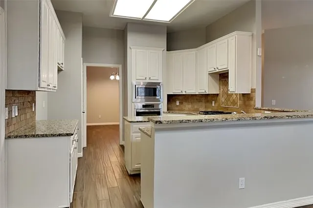 a kitchen with stainless steel appliances granite countertop a sink a stove and a refrigerator