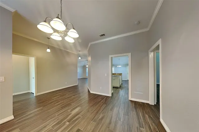 a view of a room with wooden floor and a large mirror