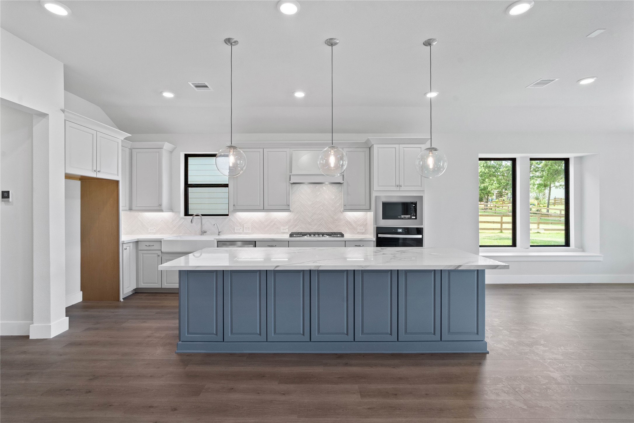 551 Black Bronco Road Magnolia, TX 77354 - Photo 16 of 50 The generously sized center island features a breakfast bar, perfect for casual dining and entertaining. The island is beautifully designed with pristine quartz countertop and elegant pendant lights.