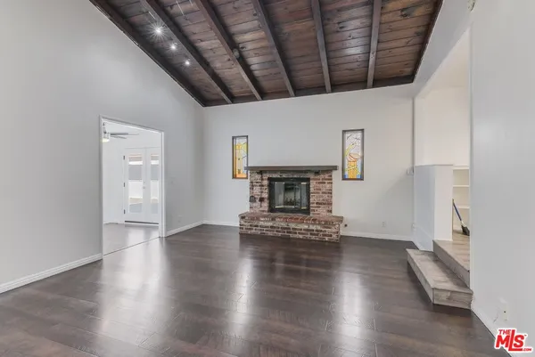 a view of empty room with wooden floor and fireplace