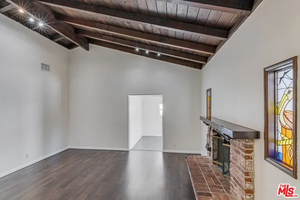 a view of small space with wooden floor and windows