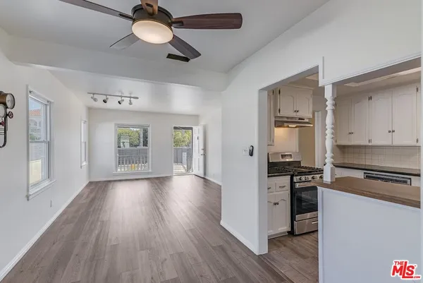 a kitchen with granite countertop a stove cabinets and wooden floor