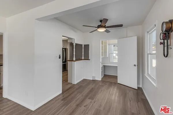 a view of empty room with wooden floor and ceiling fan