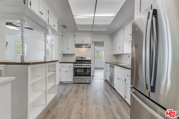 a kitchen with stainless steel appliances a refrigerator sink and cabinets