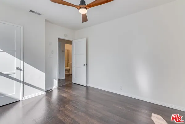 a view of an empty room with wooden floor
