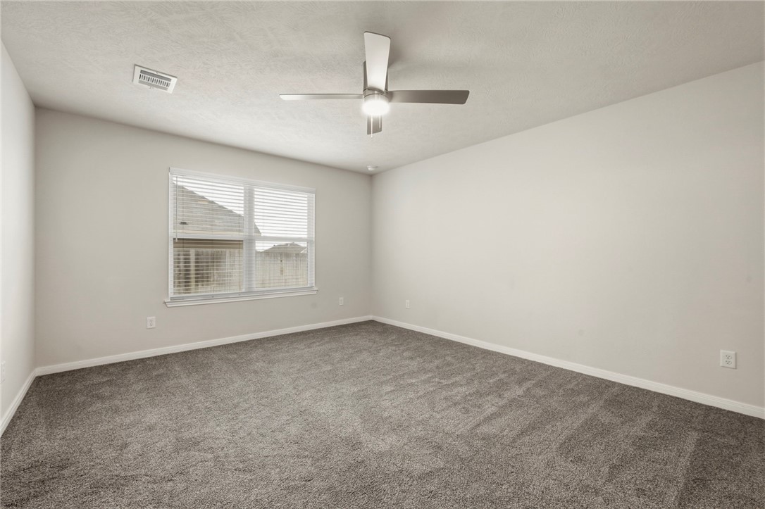 303 Camp Bowie Road Caldwell, TX 77836 - Photo 22 of 25 an empty room with chandelier fan and windows
