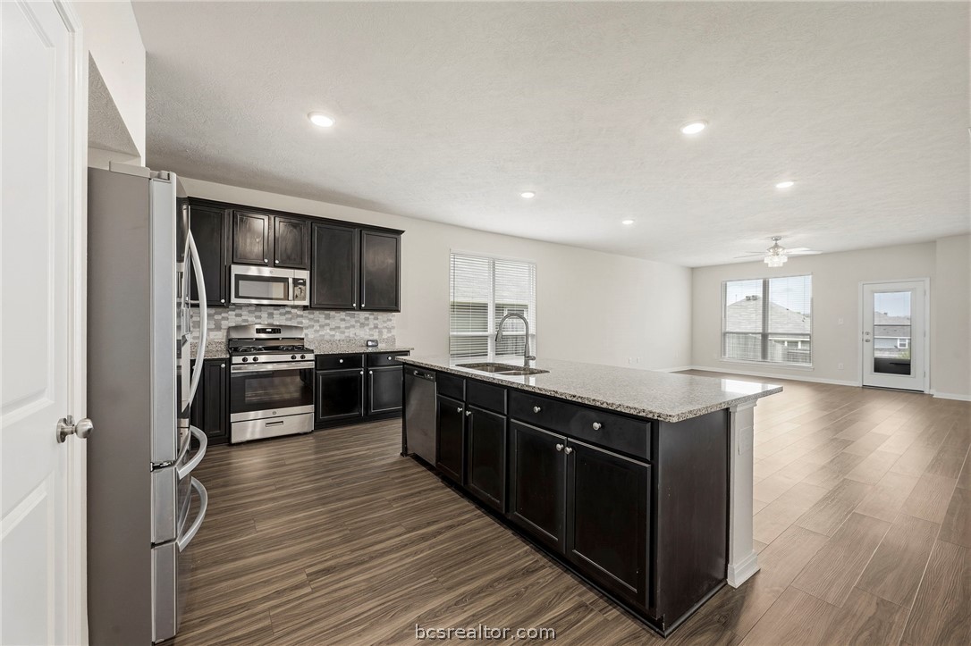 303 Camp Bowie Road Caldwell, TX 77836 - Photo 10 of 25 a kitchen with stainless steel appliances granite countertop a sink a stove top oven and wooden floors