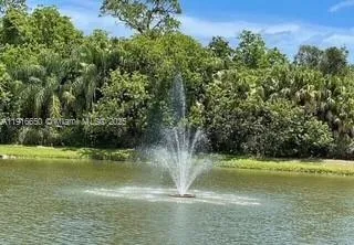 a view of a water fountain and a bench