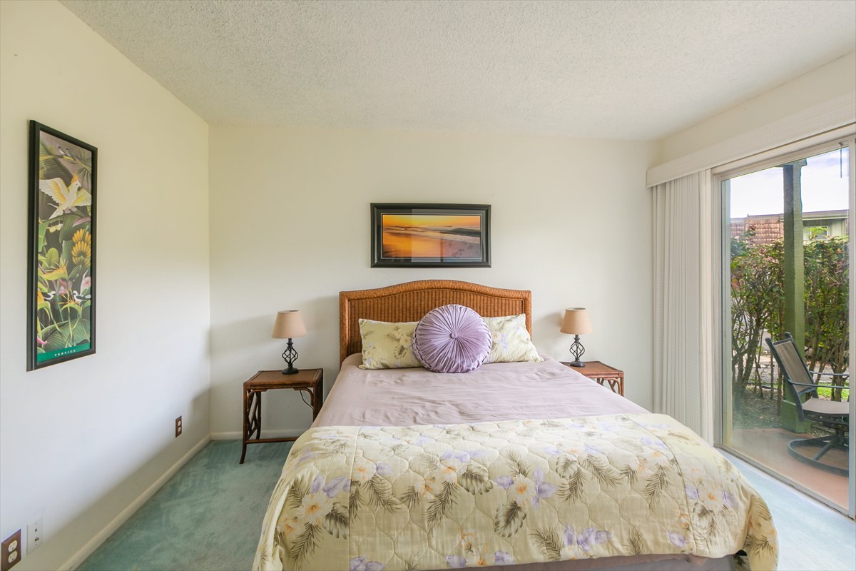 3880 Wyllie Road, Unit 8C Princeville, HI 96722 - Photo 9 of 17 a large bed sitting in a bedroom next to a window with yard