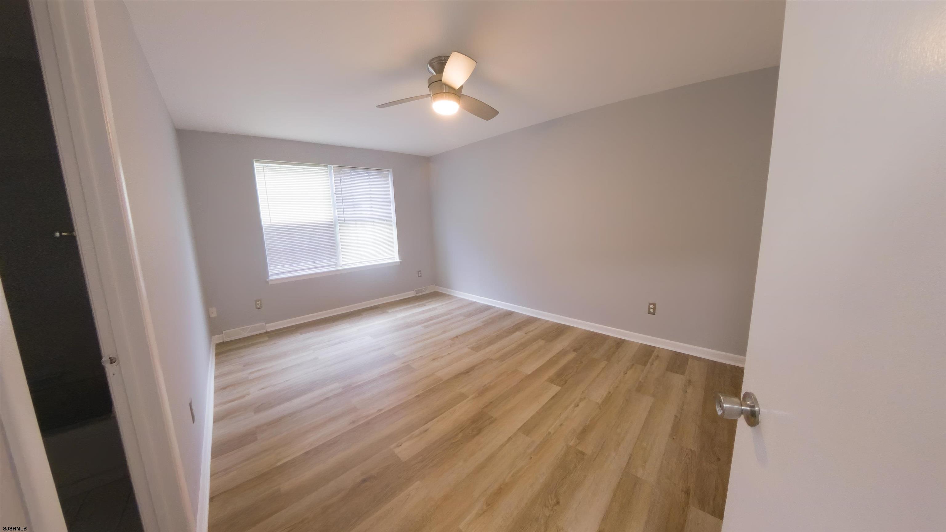2 Oyster Bay Road, Unit 2D Absecon, NJ 08205 - Photo 12 of 26 an empty room with wooden floor and windows