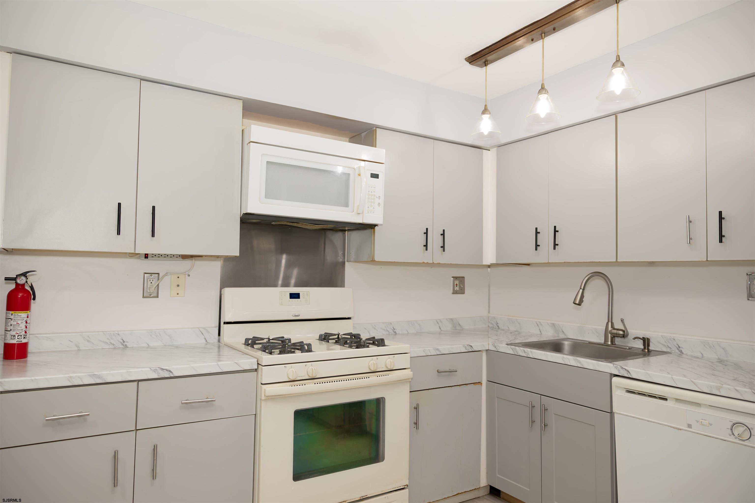 2 Oyster Bay Road, Unit 2D Absecon, NJ 08205 - Photo 15 of 26 a kitchen with cabinets appliances a sink and a counter top space