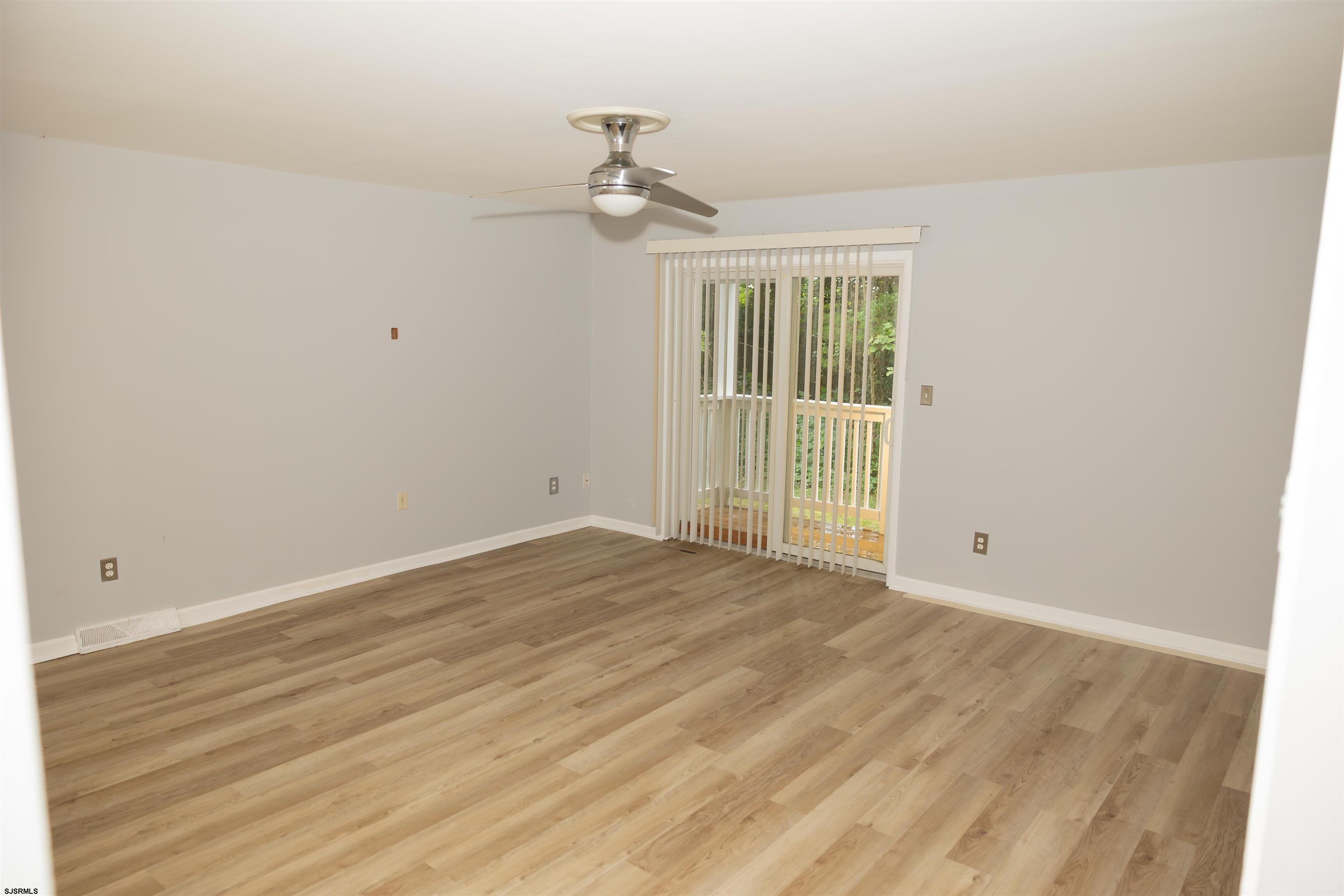 2 Oyster Bay Road, Unit 2D Absecon, NJ 08205 - Photo 18 of 26 a view of an empty room with wooden floor and a window