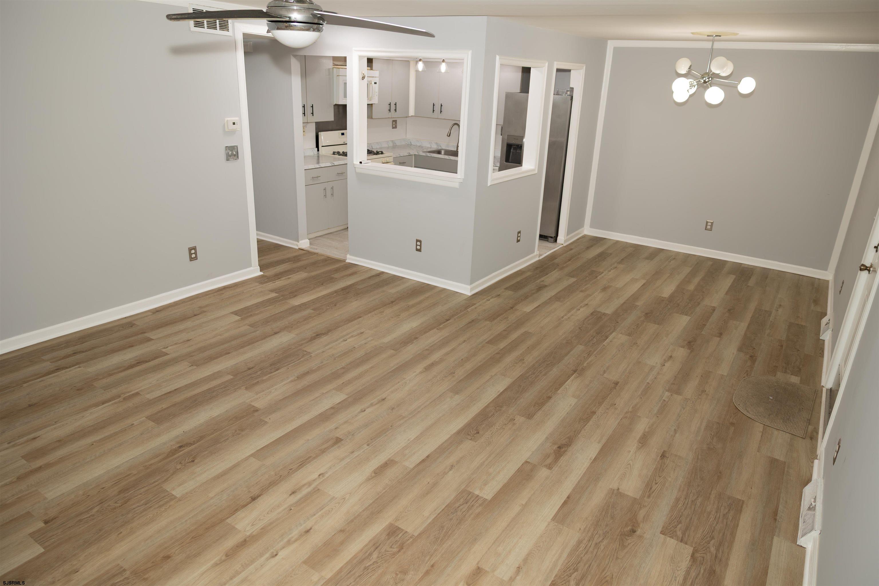 2 Oyster Bay Road, Unit 2D Absecon, NJ 08205 - Photo 21 of 26 a view of a hallway with wooden floor and a refrigerator