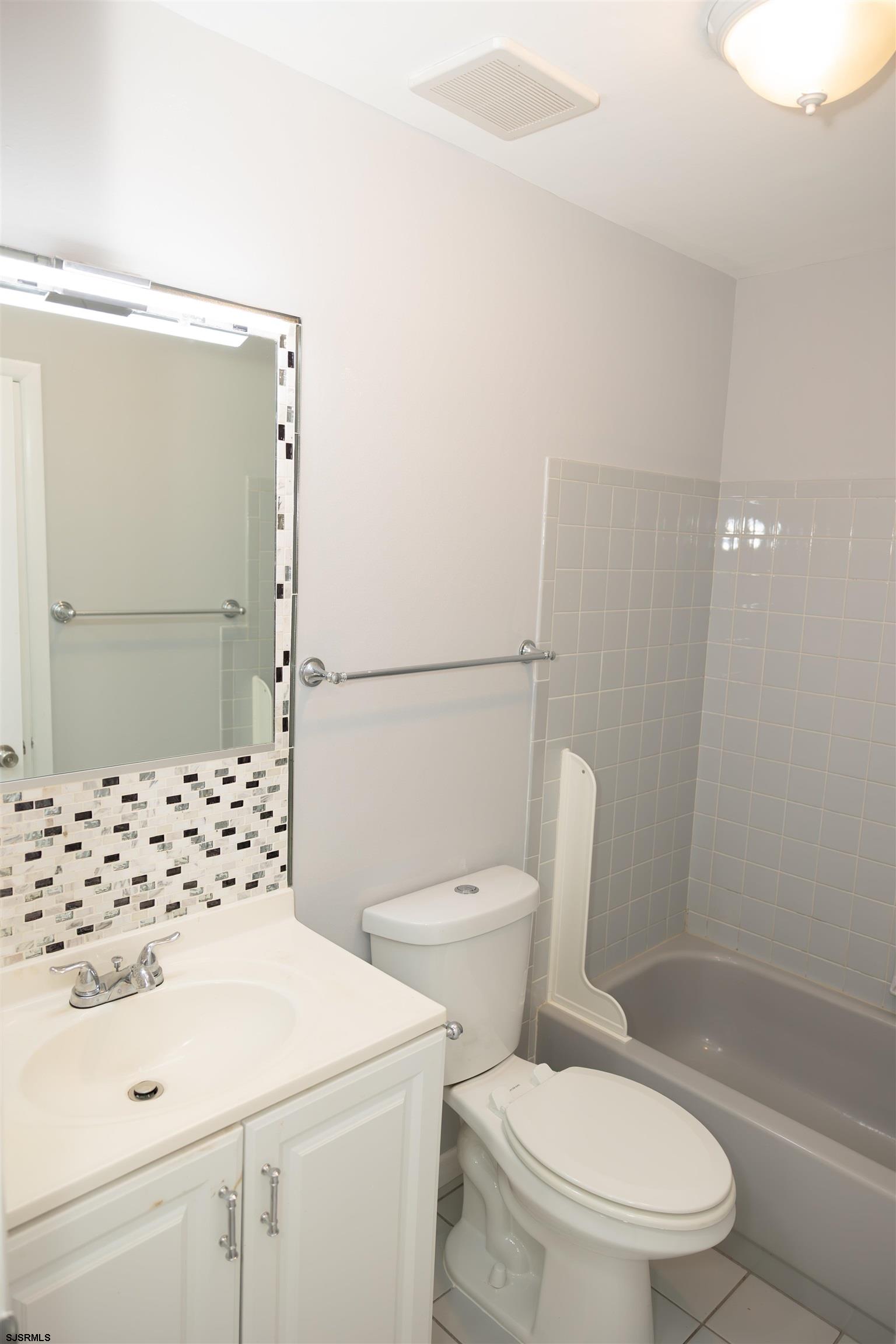 2 Oyster Bay Road, Unit 2D Absecon, NJ 08205 - Photo 23 of 26 a white toilet sitting next to a bathroom sink