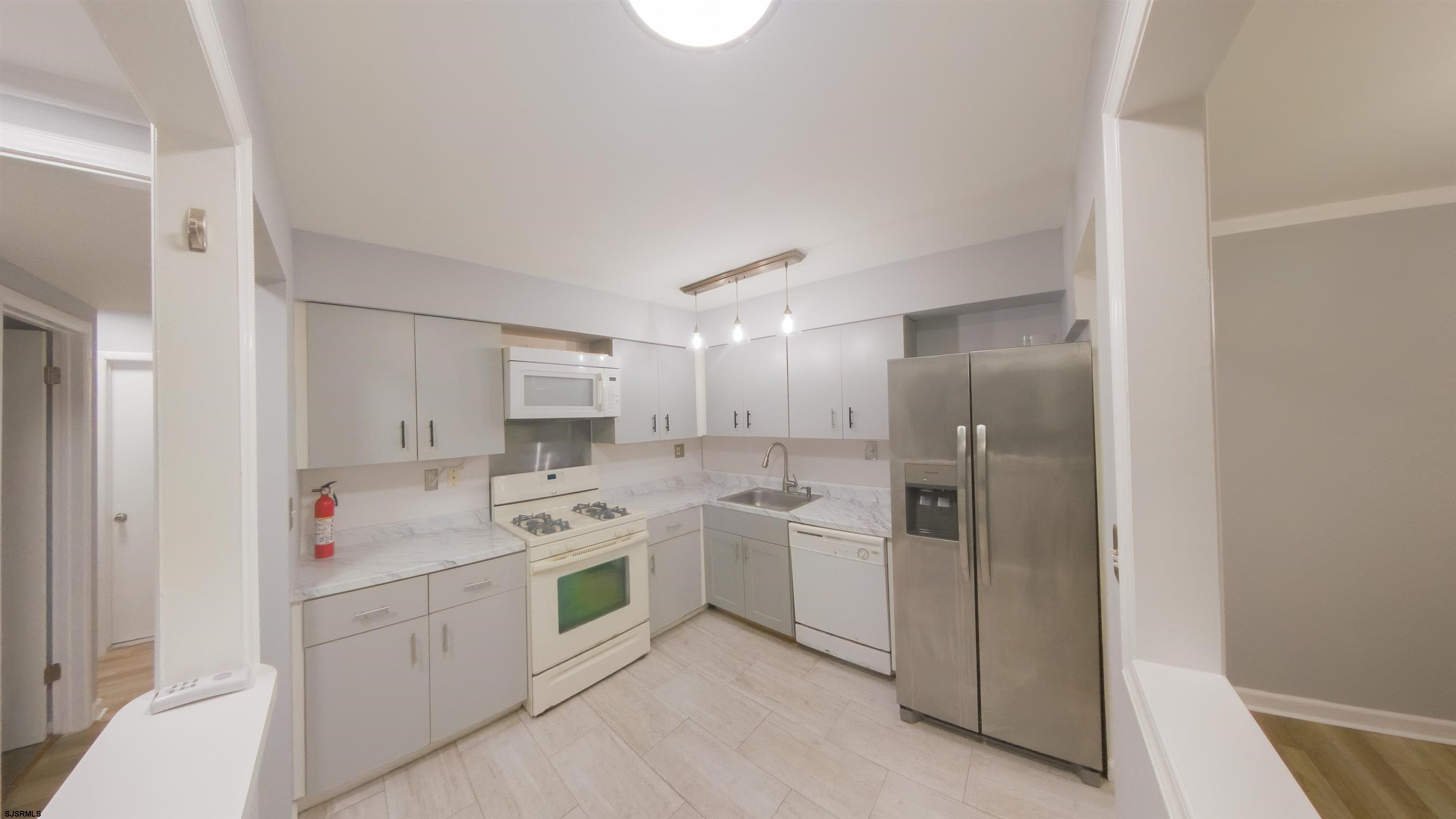 2 Oyster Bay Road, Unit 2D Absecon, NJ 08205 - Photo 3 of 26 a kitchen with a sink cabinets and stainless steel appliances