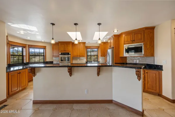 a kitchen with stainless steel appliances granite countertop a stove a sink and a refrigerator